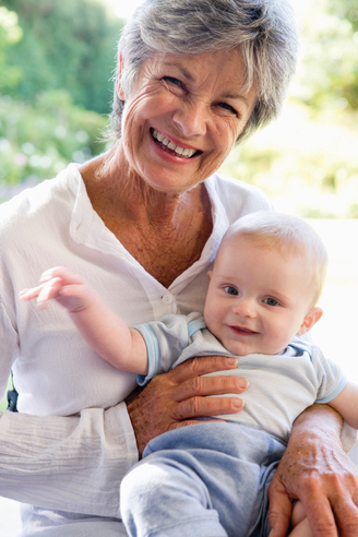 Grandmother outdoors on patio with baby smiling during summer